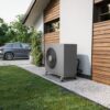 Pompe à chaleur Intuis HTi70 Premium+ installée en extérieur Unité extérieure de pompe à chaleur Intuis HTi70 Premium+ posée sur lit de gravier le long d'une maison à bardage bois