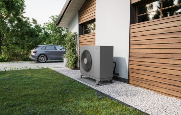Pompe à chaleur Intuis HTi70 Premium+ installée en extérieur Unité extérieure de pompe à chaleur Intuis HTi70 Premium+ posée sur lit de gravier le long d'une maison à bardage bois